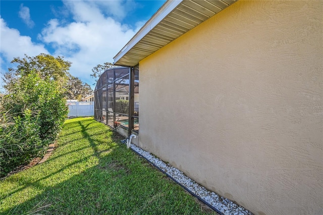 view of home's exterior with a lanai and a yard