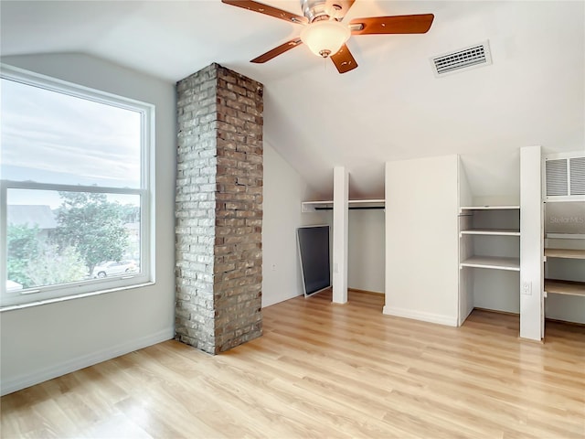 additional living space with brick wall, ceiling fan, vaulted ceiling, and light wood-type flooring