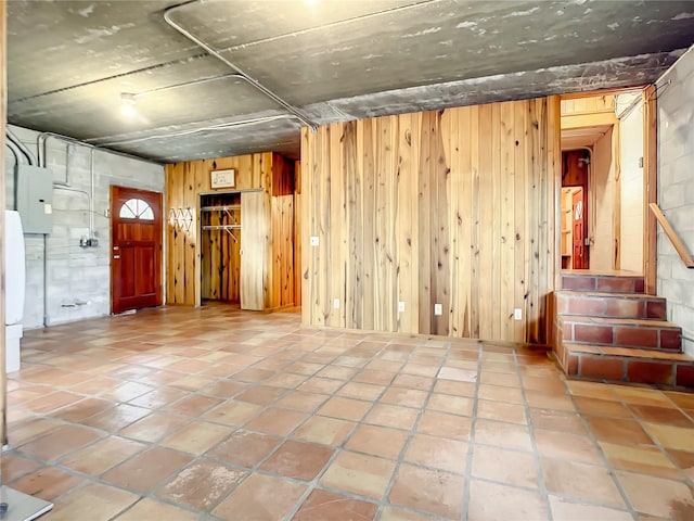 empty room with wood walls and light tile floors