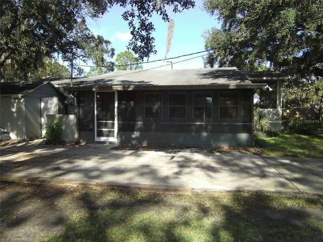 rear view of house featuring a sunroom