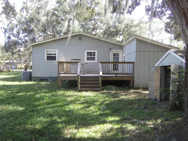 back of property with central AC, a deck, and a yard