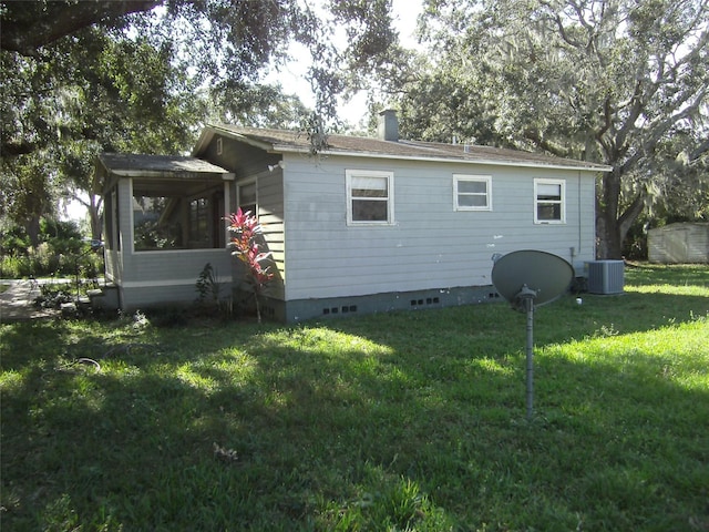 rear view of property featuring a yard and central air condition unit