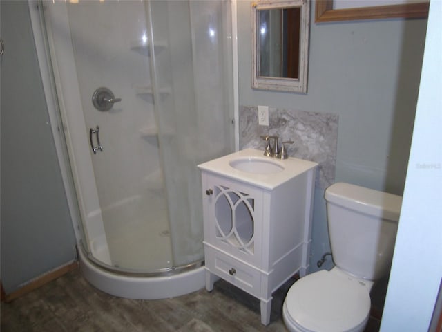 bathroom with an enclosed shower, vanity, wood-type flooring, and toilet