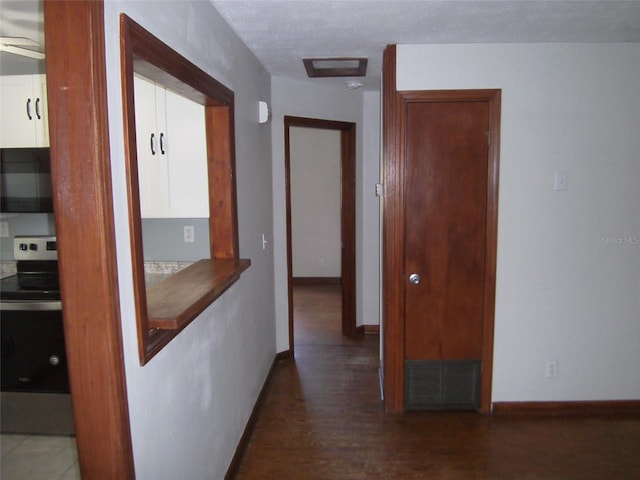 corridor featuring a textured ceiling and dark wood-type flooring