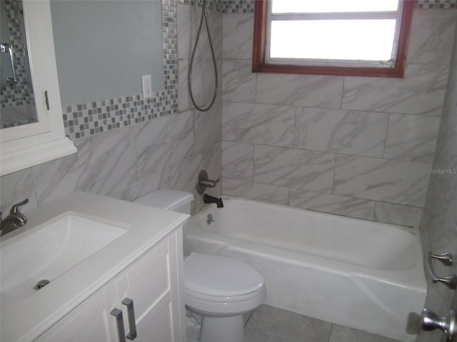 full bathroom with vanity, tiled shower / bath combo, toilet, and tile walls