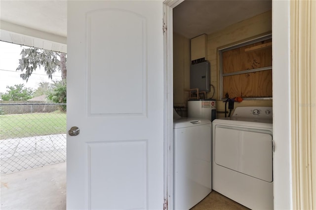 clothes washing area with water heater and separate washer and dryer