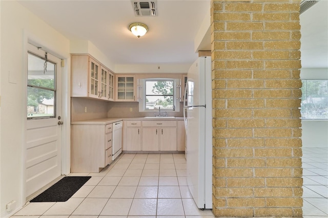 kitchen with backsplash, white appliances, sink, and light tile floors