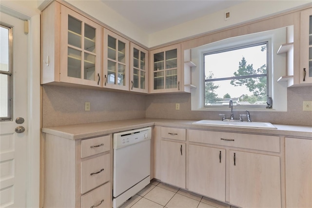 kitchen featuring light tile floors, tasteful backsplash, light brown cabinetry, dishwasher, and sink