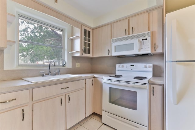 kitchen featuring light brown cabinets, white appliances, sink, and light tile floors