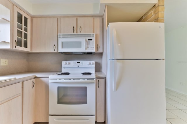 kitchen with white appliances, light brown cabinetry, and light tile flooring