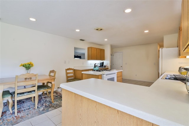 kitchen featuring white appliances, kitchen peninsula, and light tile floors