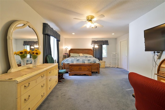 bedroom featuring a textured ceiling, ceiling fan, and dark colored carpet