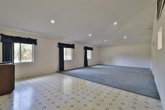 tiled spare room featuring vaulted ceiling and a wealth of natural light