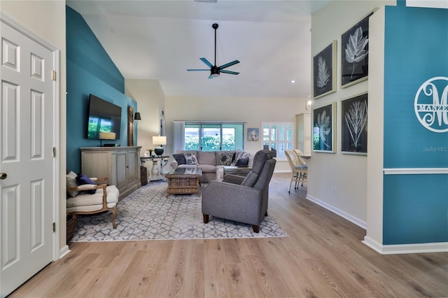 living room with high vaulted ceiling, light hardwood / wood-style floors, and ceiling fan