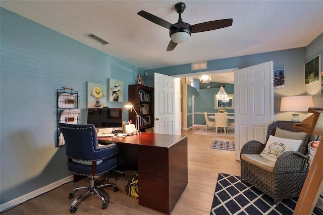 office area with light wood-type flooring and ceiling fan with notable chandelier