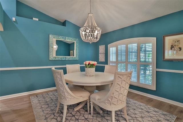 dining room with an inviting chandelier, lofted ceiling, and dark hardwood / wood-style floors