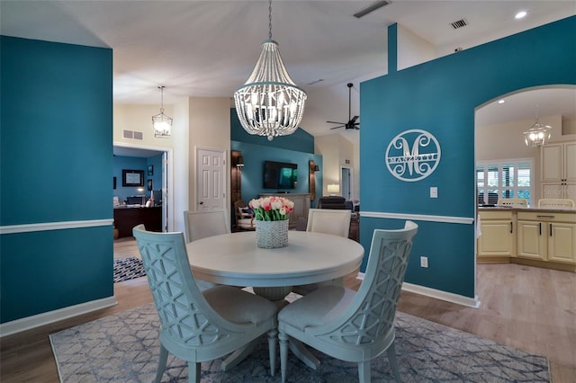 dining room featuring ceiling fan with notable chandelier and hardwood / wood-style flooring