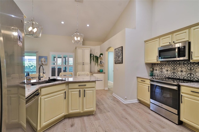 kitchen featuring decorative light fixtures, light wood-type flooring, sink, and stainless steel appliances