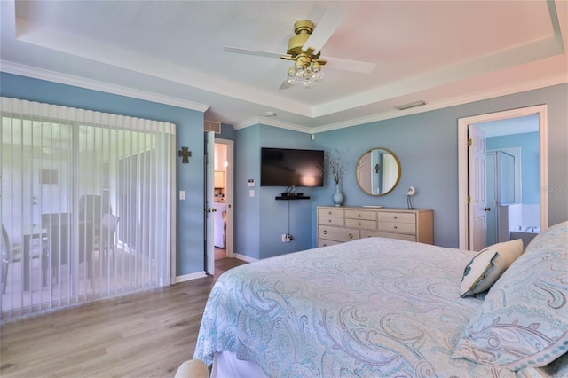 bedroom featuring ceiling fan, a raised ceiling, hardwood / wood-style flooring, and ornamental molding