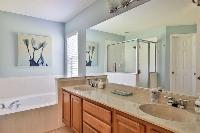 bathroom with vanity with extensive cabinet space, dual sinks, and separate shower and tub