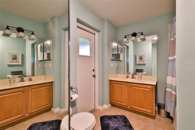 bathroom featuring a textured ceiling, vanity with extensive cabinet space, and toilet