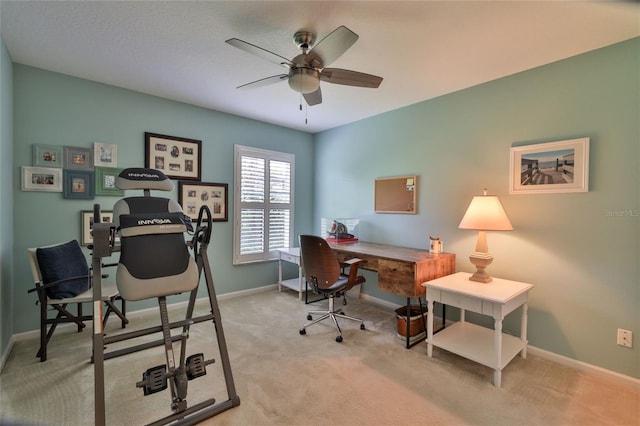 carpeted office space featuring ceiling fan