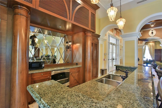 263 Minorca Beach Way Unit 803, New Smyrna Beach, FL 32169 - kitchen featuring light stone countertops, decorative light fixtures, sink, crown molding, and ornate columns
