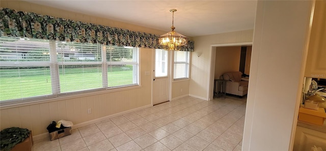 unfurnished dining area featuring light tile floors and a notable chandelier