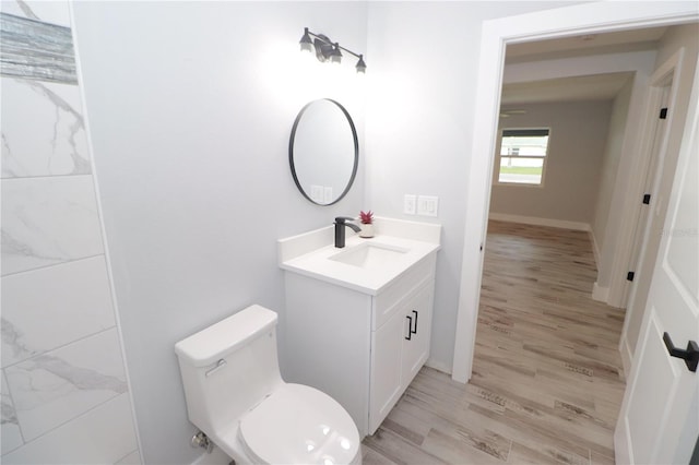 bathroom featuring toilet, vanity, and hardwood / wood-style flooring