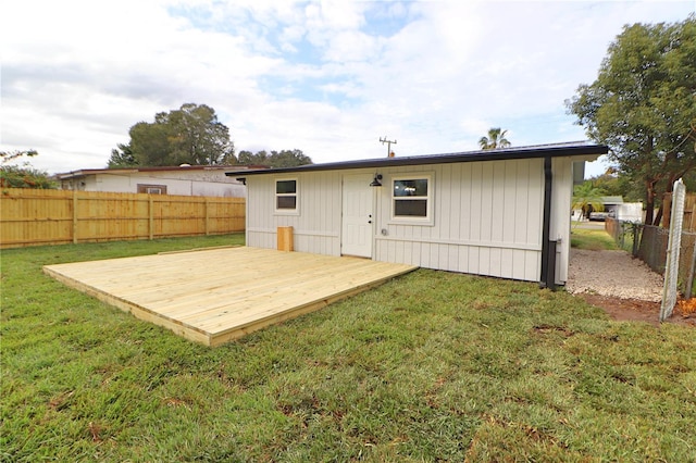 back of house with a deck and a yard