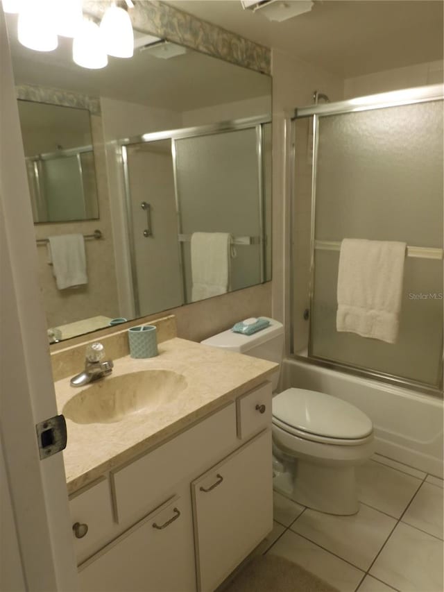 full bathroom featuring enclosed tub / shower combo, toilet, tile floors, and vanity