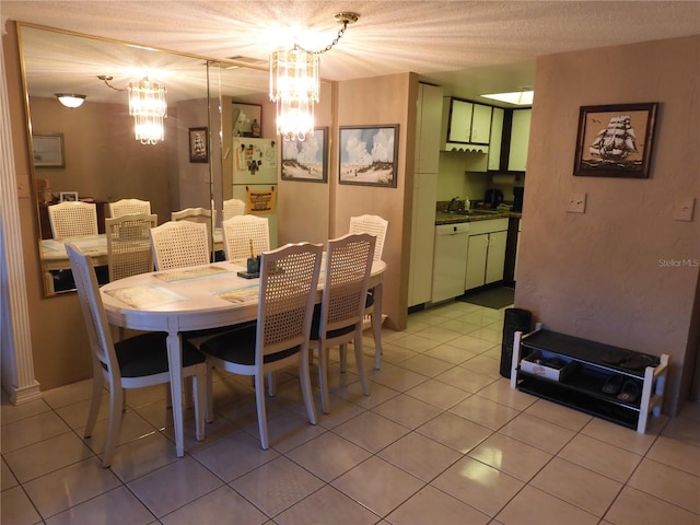 dining room featuring a textured ceiling, light tile flooring, sink, and a chandelier