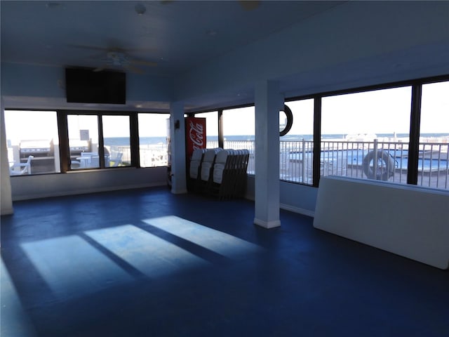 unfurnished room featuring a water view and ceiling fan