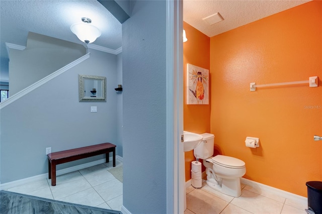 bathroom with crown molding, toilet, a textured ceiling, and tile floors