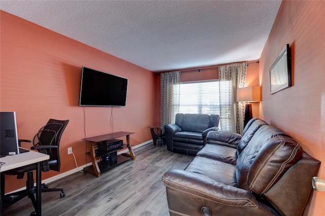 living room with a textured ceiling and light hardwood / wood-style flooring