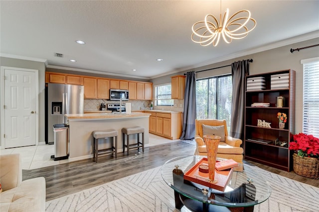 living room with a chandelier, light hardwood / wood-style flooring, and crown molding