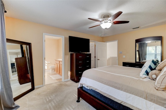 carpeted bedroom featuring connected bathroom, ceiling fan, and a textured ceiling