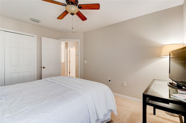 carpeted bedroom featuring a closet and ceiling fan