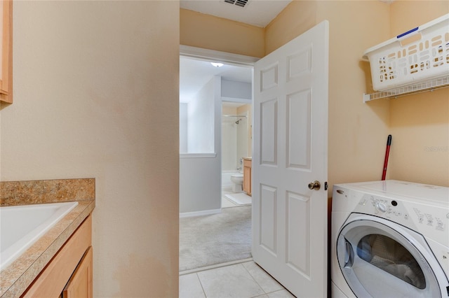 washroom featuring light tile flooring, washer / dryer, and sink