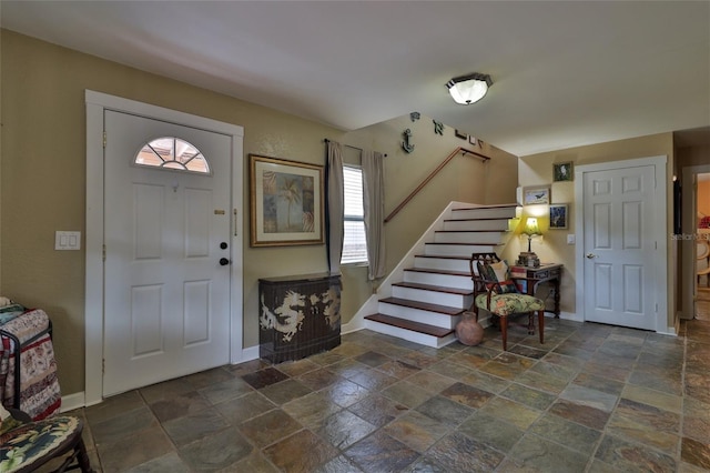 foyer entrance featuring plenty of natural light and dark tile flooring