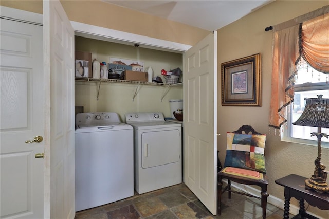 washroom with washer hookup, dark tile floors, and separate washer and dryer