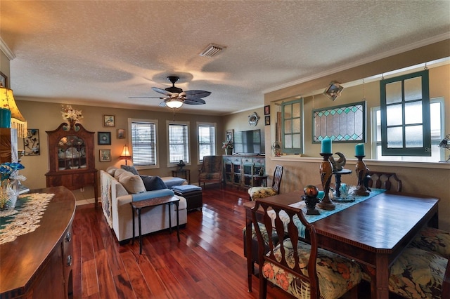 dining room featuring ceiling fan, dark wood-type flooring, a textured ceiling, and crown molding