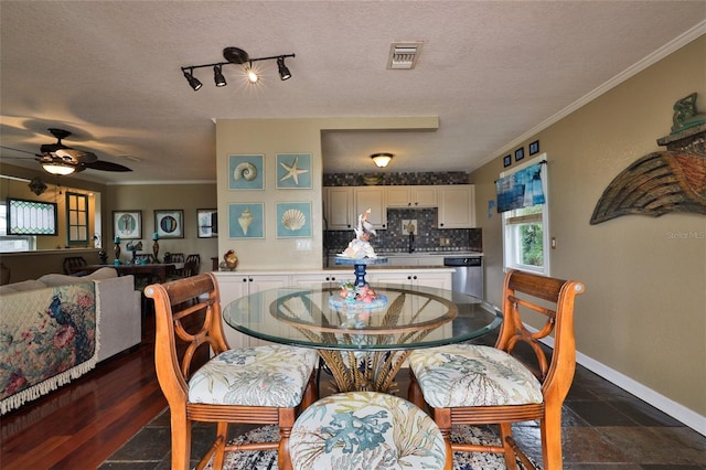 tiled dining space with ceiling fan, a textured ceiling, and crown molding