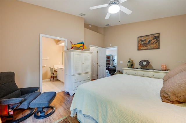 bedroom featuring ensuite bath, light hardwood / wood-style floors, and ceiling fan