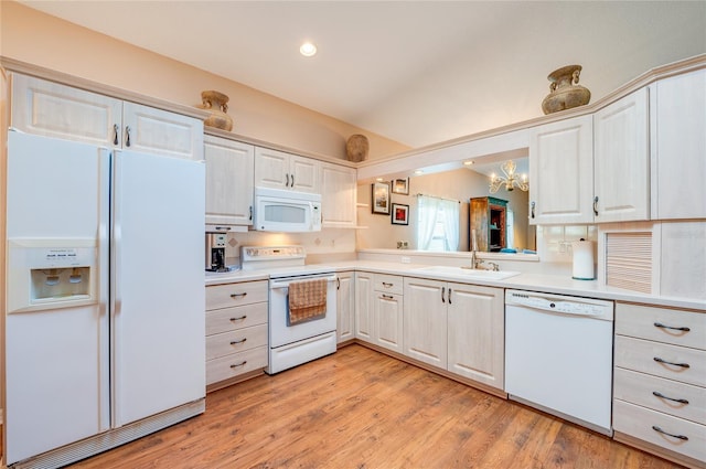 kitchen featuring white appliances, a notable chandelier, sink, and light hardwood / wood-style flooring