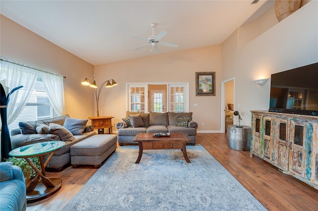 living room featuring a wealth of natural light, vaulted ceiling, ceiling fan, and hardwood / wood-style flooring