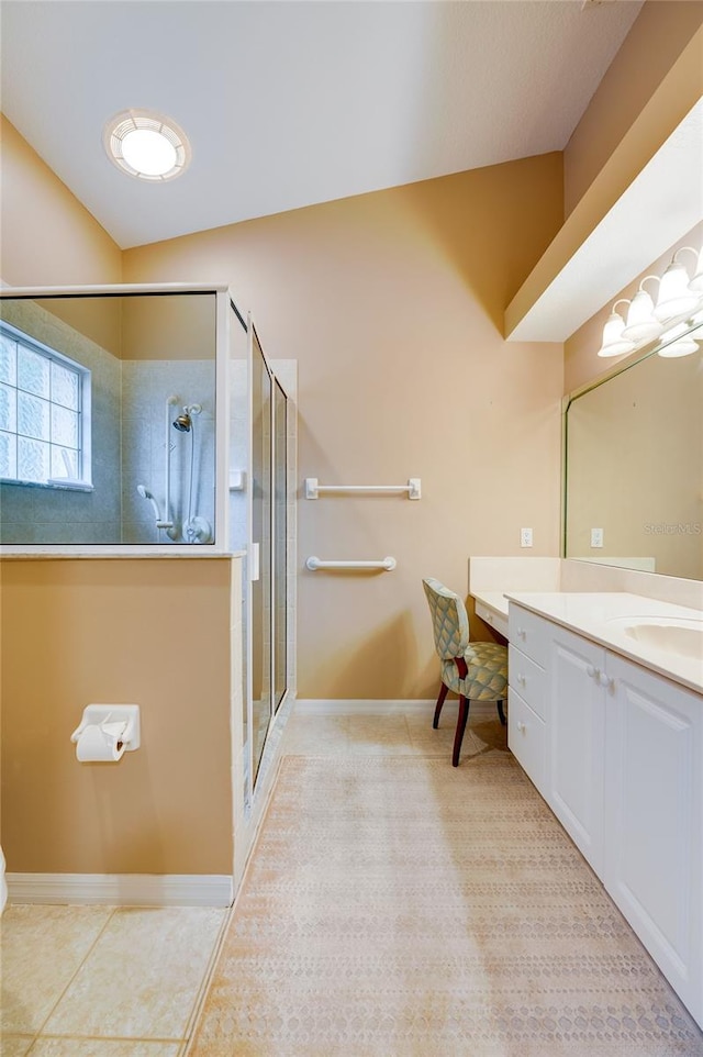 bathroom with walk in shower, tile flooring, vanity, and lofted ceiling