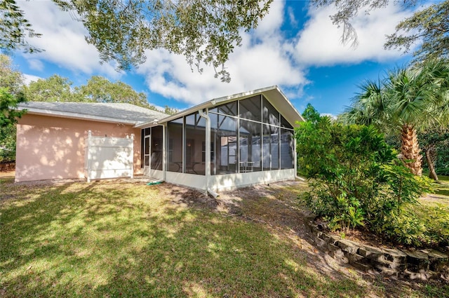 rear view of house with a sunroom and a yard