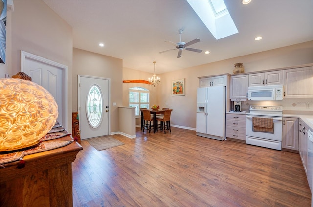 kitchen featuring decorative light fixtures, white appliances, wood-type flooring, and ceiling fan with notable chandelier