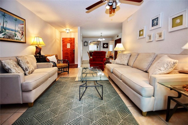 living room with light tile flooring and ceiling fan with notable chandelier